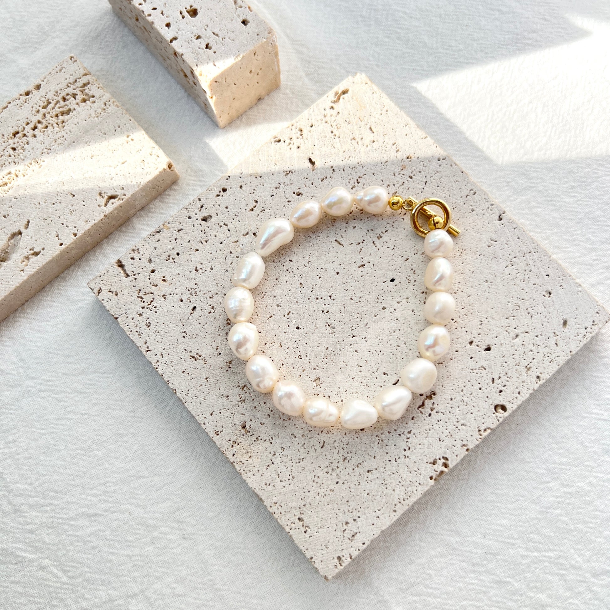 Woman wearing 14K gold-filled baroque pearl bracelet, showcasing elegant bridal jewelry style