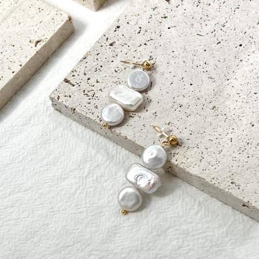 Close-up of 14K gold baroque pearl dangling earrings, minimalist and dainty craftsmanship