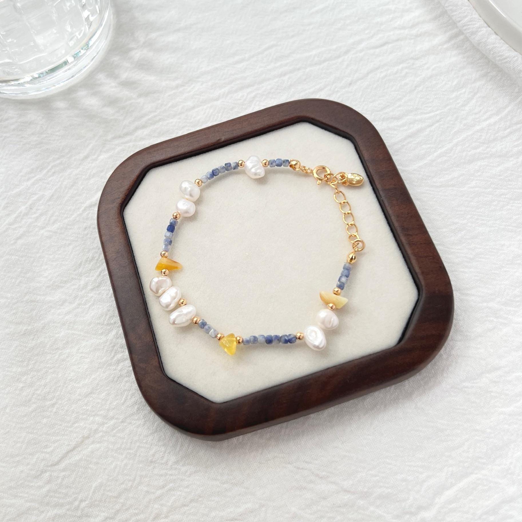 Close-up of baroque pearls, lapis lazuli stones, and beeswax beads on bracelet