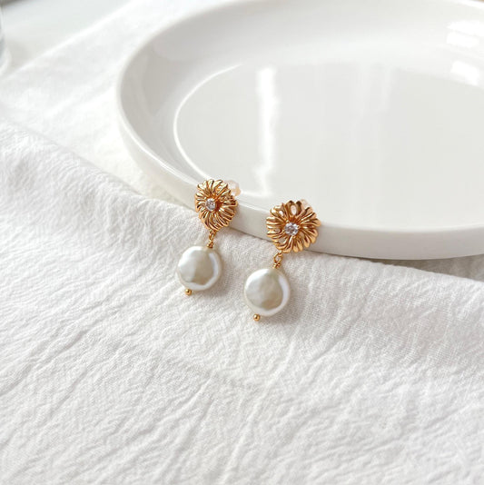 Close-up of baroque pearl and zircon detail on 18K gold earrings