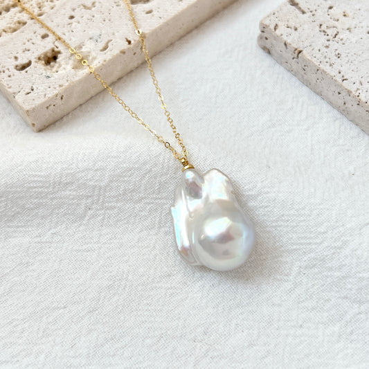 Close-up of large natural baroque pearl on 14K gold-filled necklace