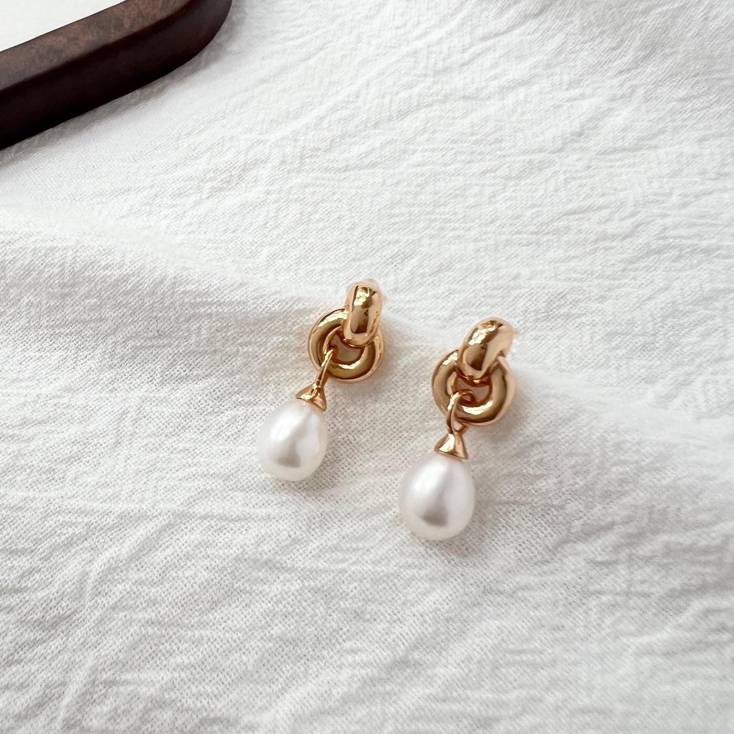 Close-up of vintage pearl and Celtic knot detail on 18K gold earrings
