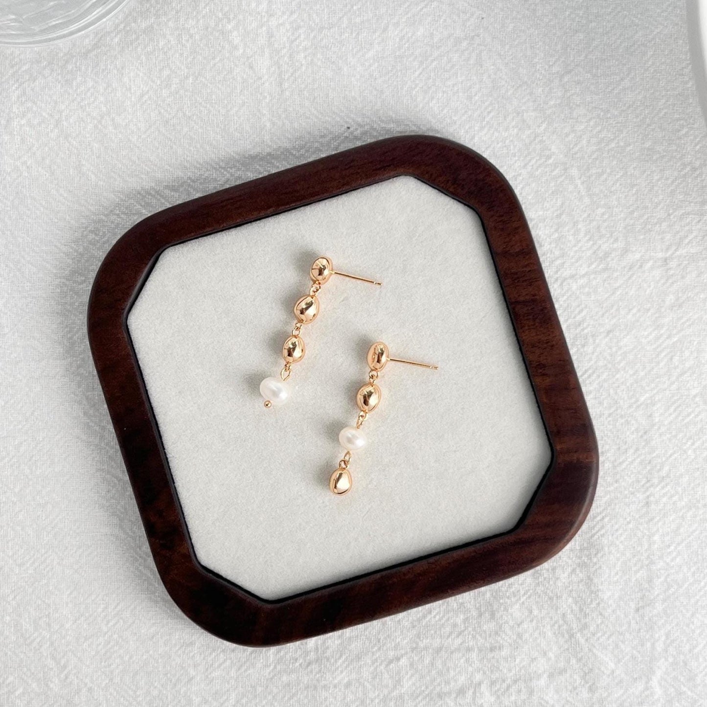 Model wearing 18K gold beaded freshwater baroque pearl drop earrings