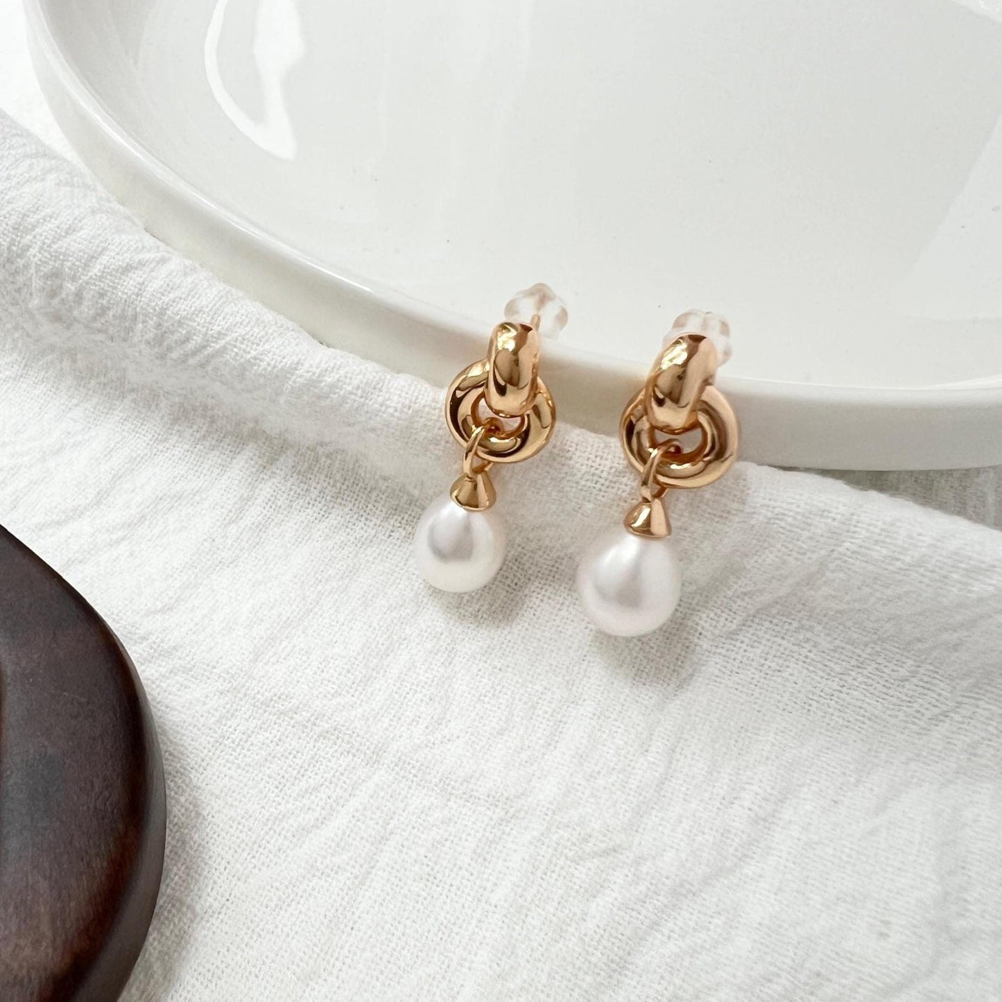 Model wearing 18K gold vintage pearl dangling earrings with Celtic knot design