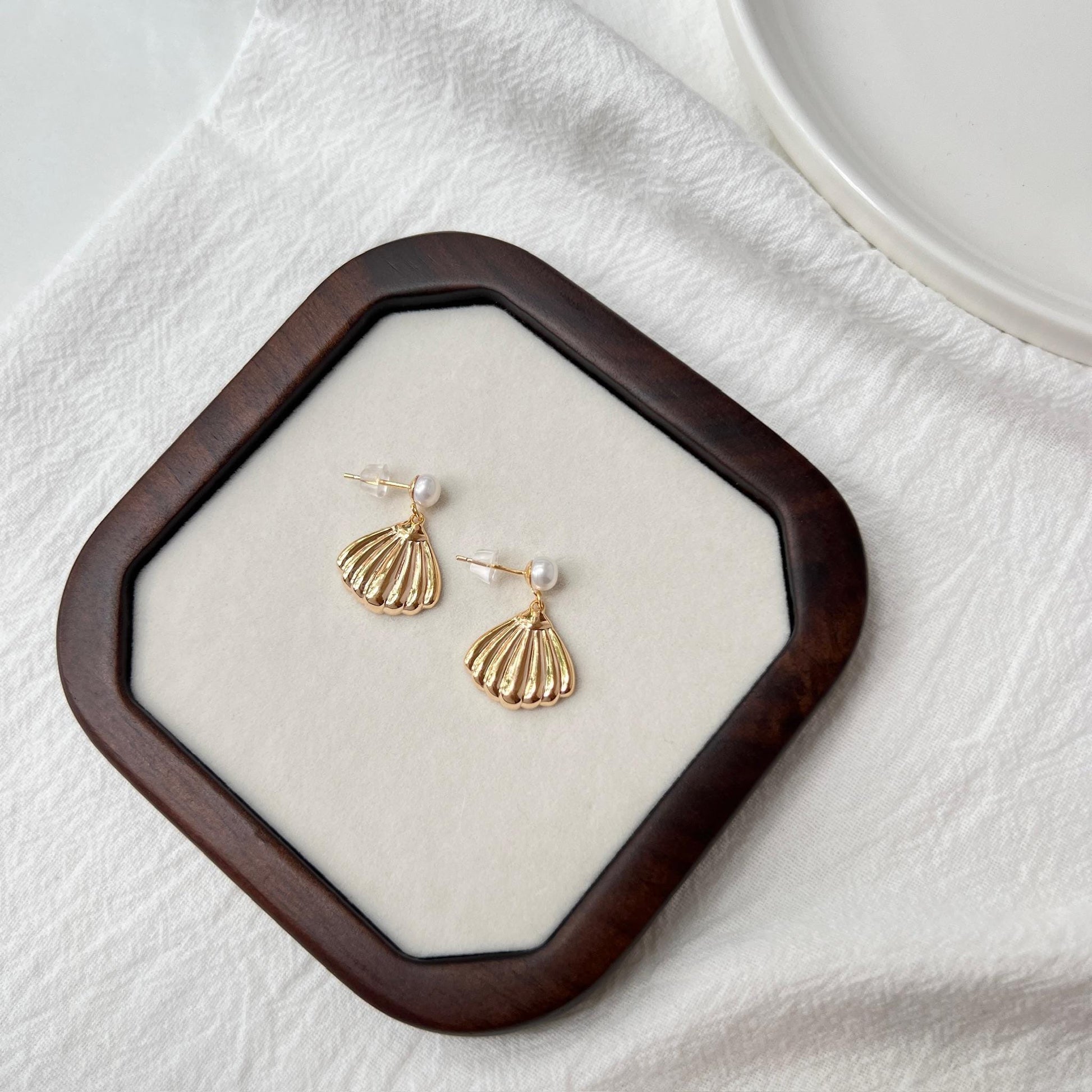 Ocealine Jewelry branding image featuring 18K gold shell drop earrings with pearl studs