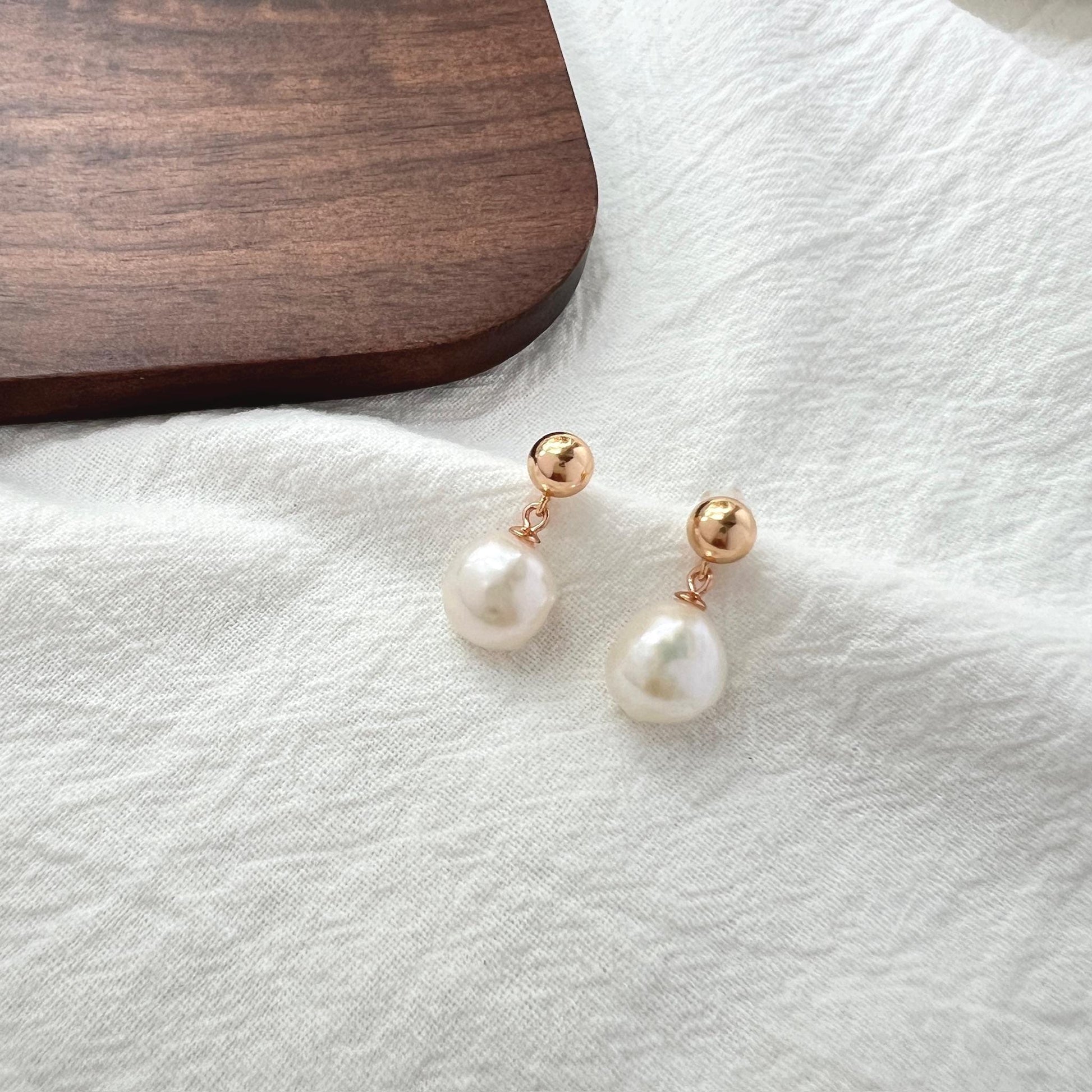 Ocealine Jewelry branding image featuring 18K gold baroque pearl teardrop earrings