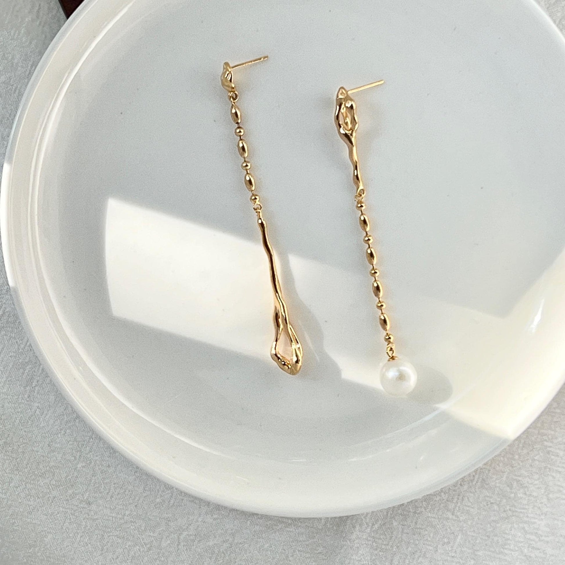 Ocealine Jewelry branded image featuring 18K gold asymmetrical pearl drop earrings