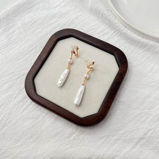 Side view of 18K gold baroque pearl bar drop earrings
