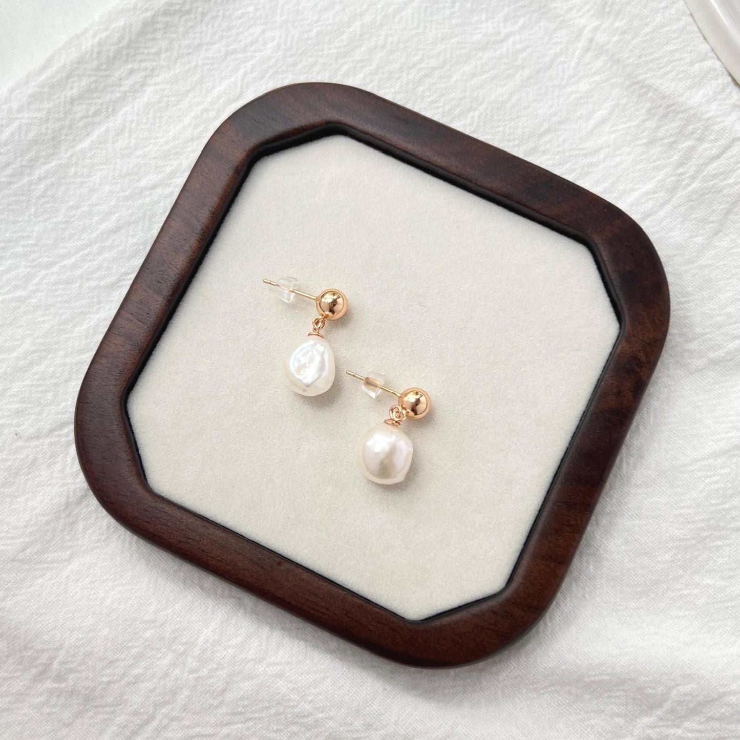Side view of 18K gold teardrop earrings with baroque pearls