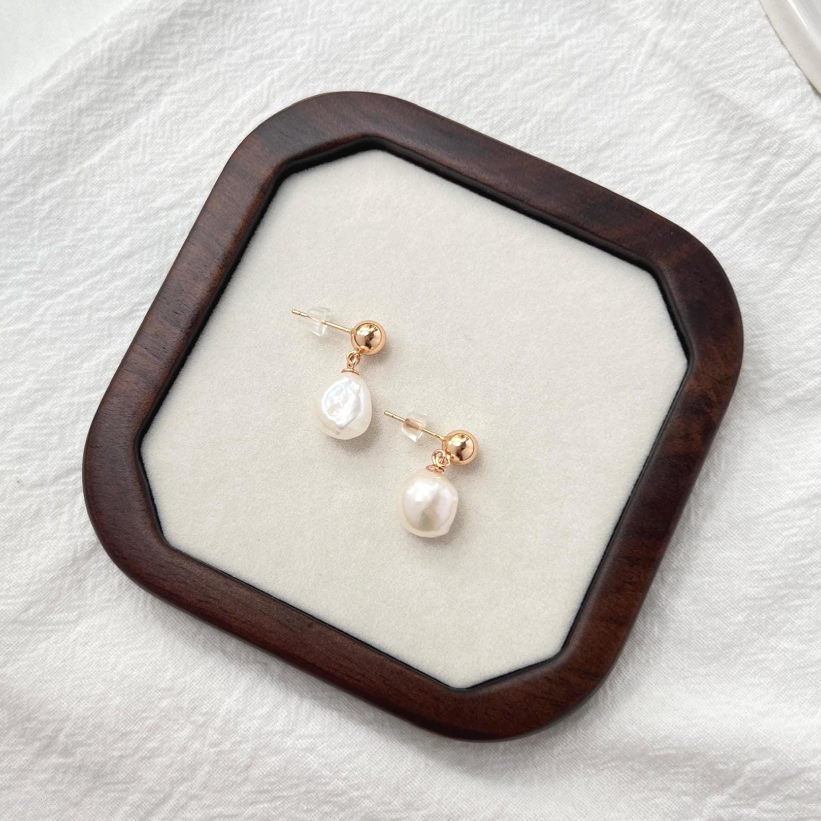 Side view of 18K gold teardrop earrings with baroque pearls
