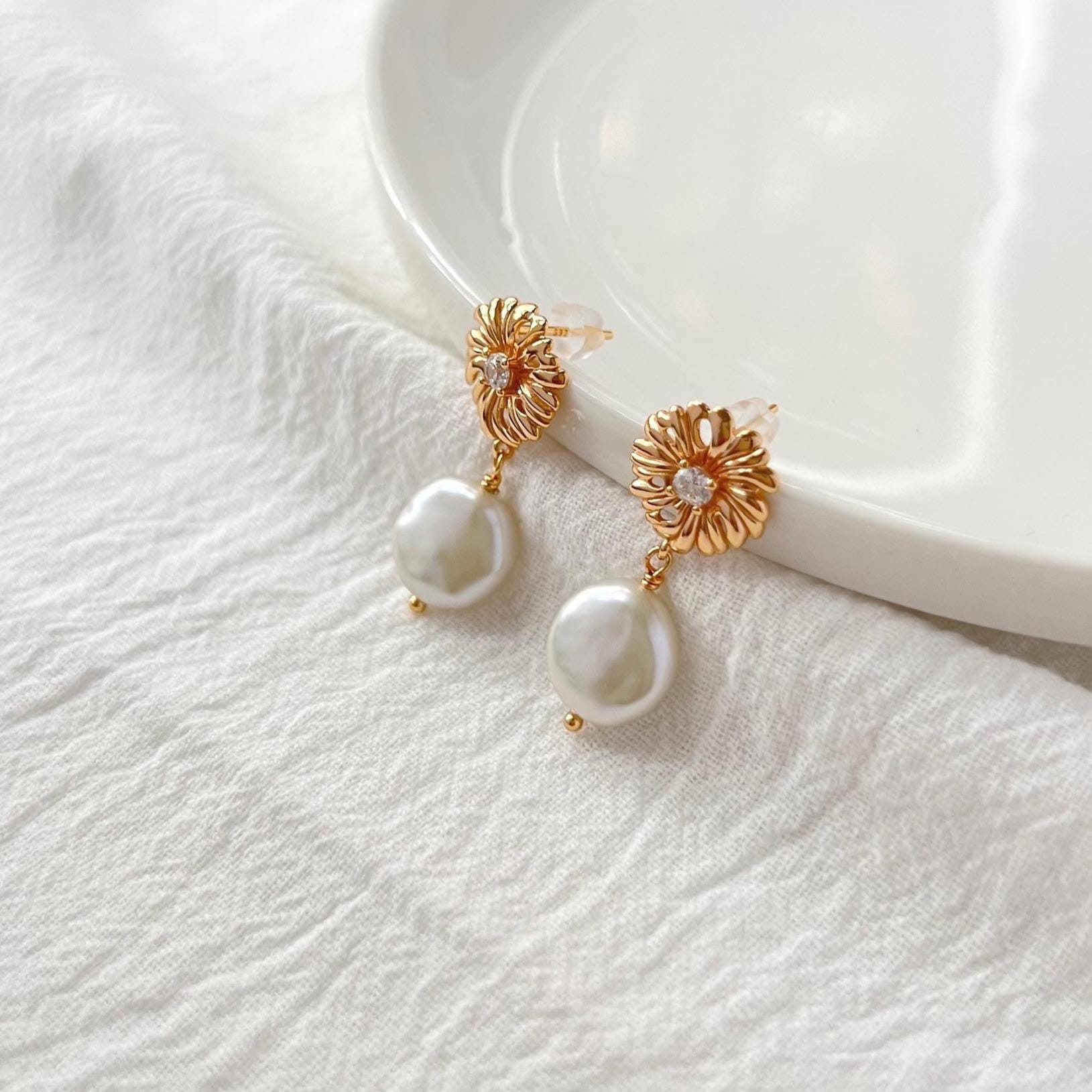 Side view of 18K gold baroque pearl and zircon drop earrings