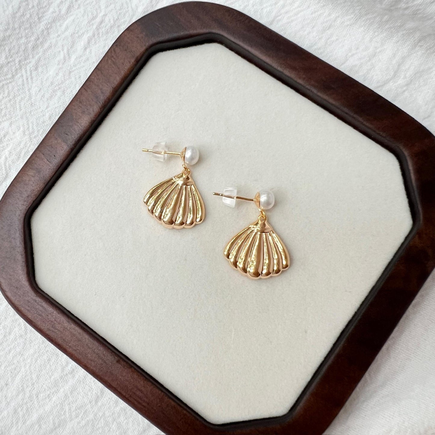 Side view of 18K gold vintage shell drop earrings with pearl studs