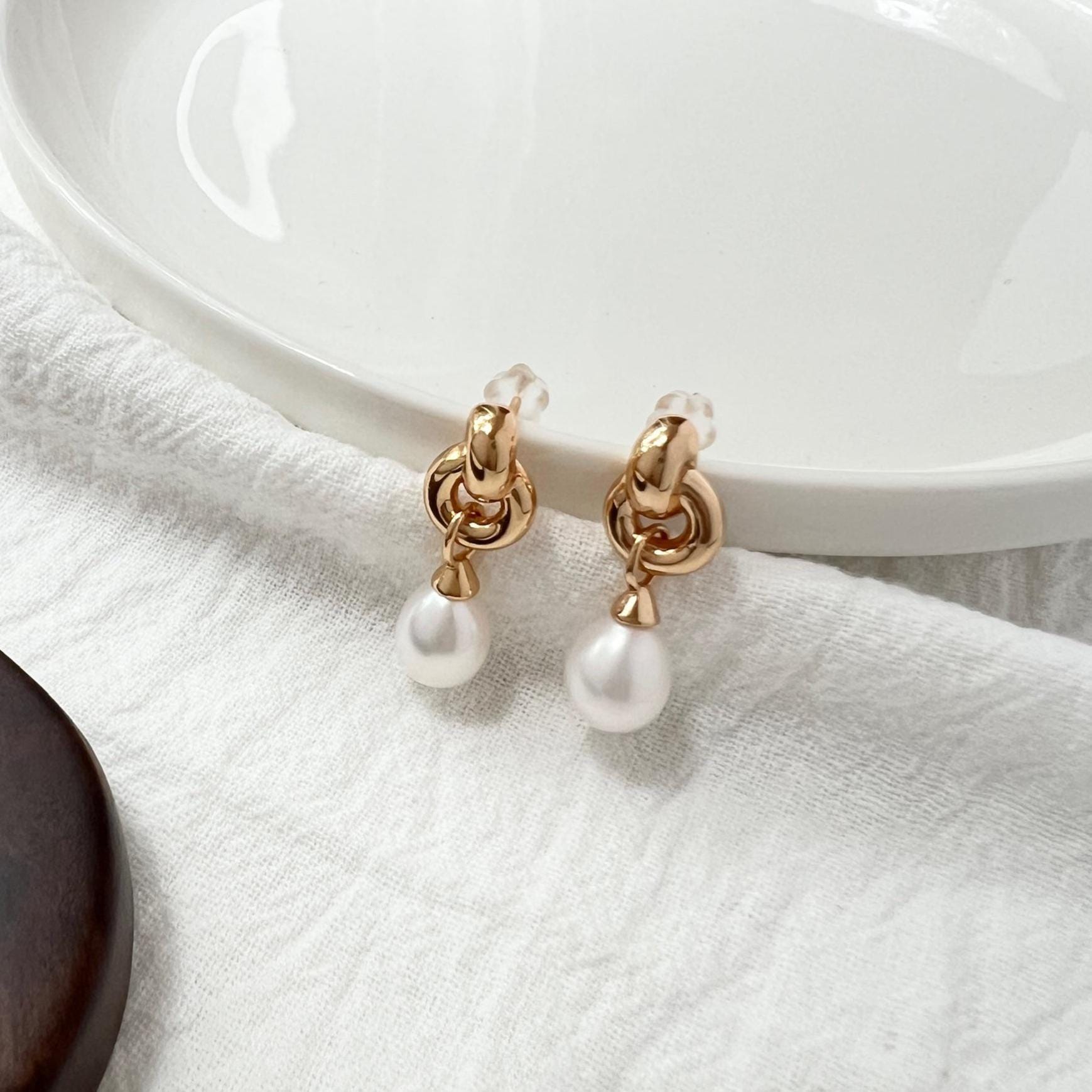 Side view of 18K gold vintage pearl dangling earrings with Celtic knot design
