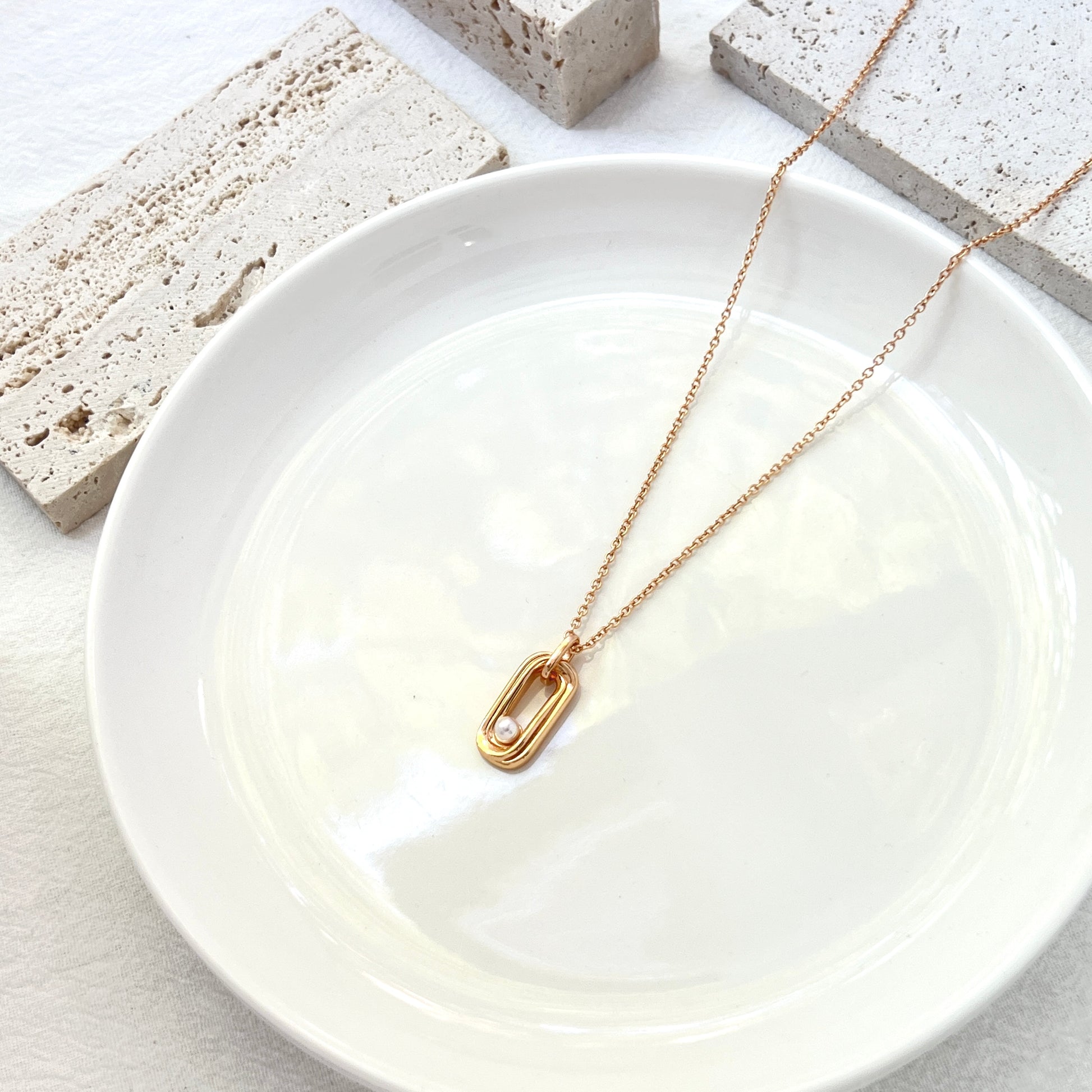 Side view showing minimalist 18K gold bar and pearl detail