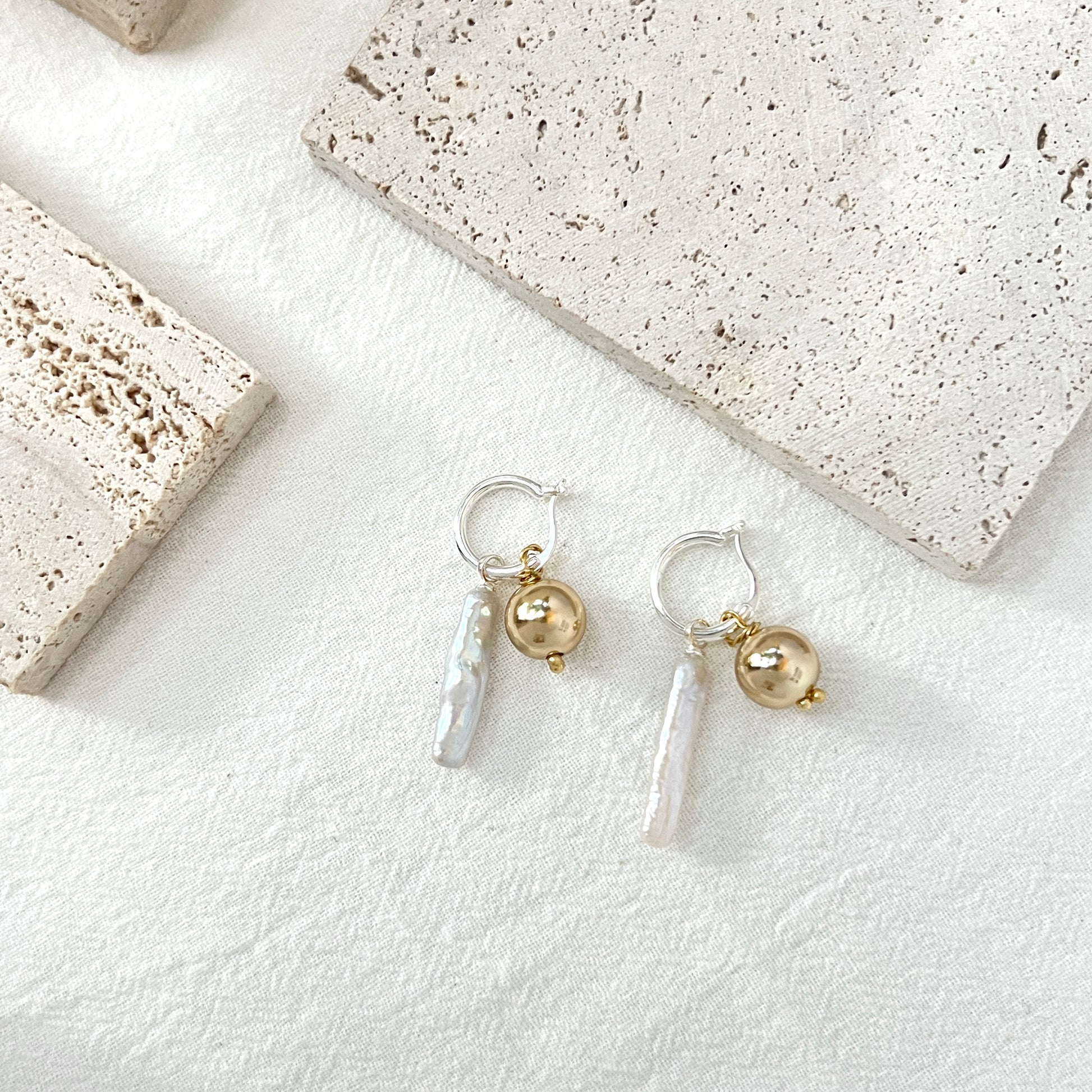 Close-up of 14K gold-filled baroque pearl earrings, highlighting gold ball and delicate design