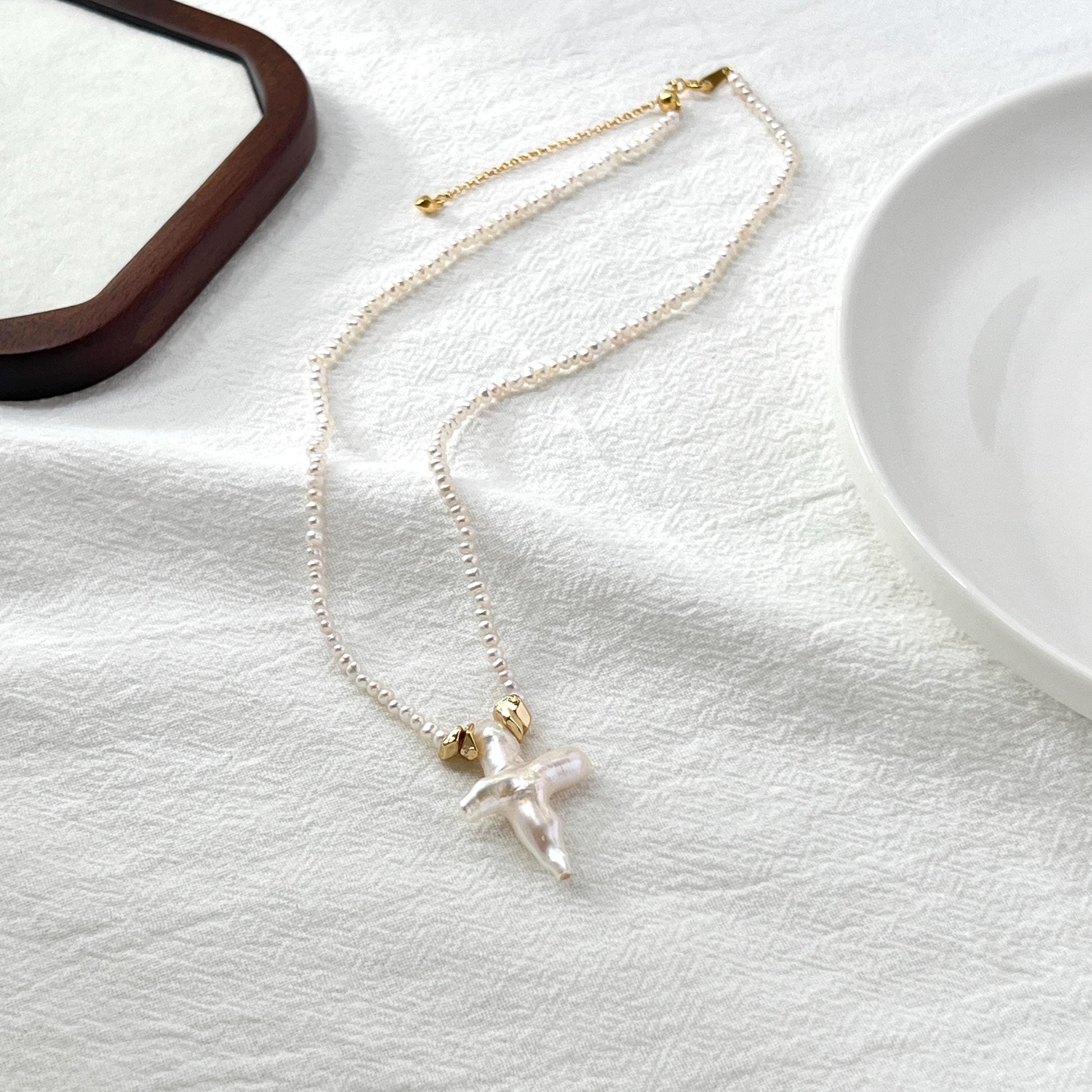 Necklace with a cross pendant on a white surface