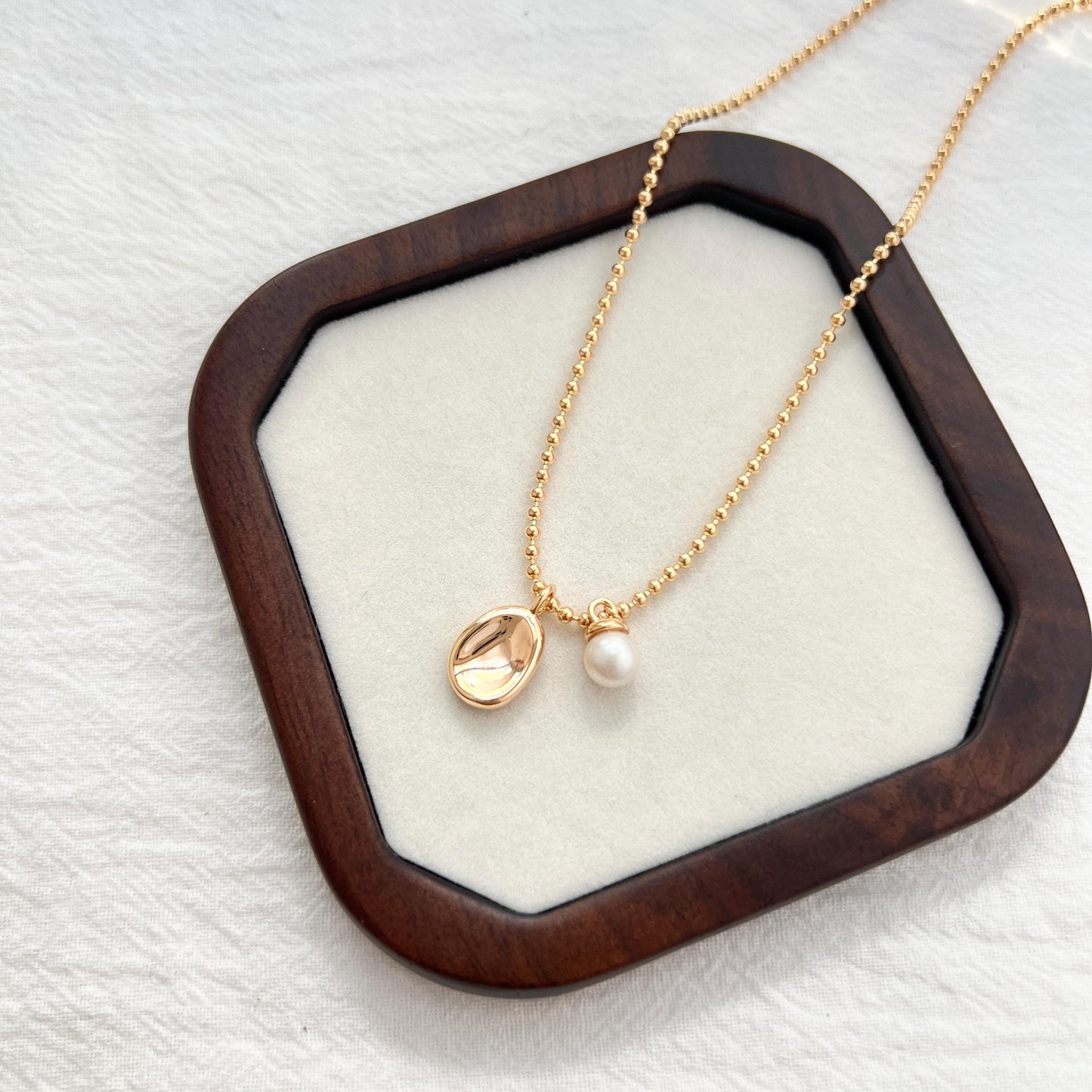 Golden Bean Pendant With Petite Freshwater Pearl Charm Necklace