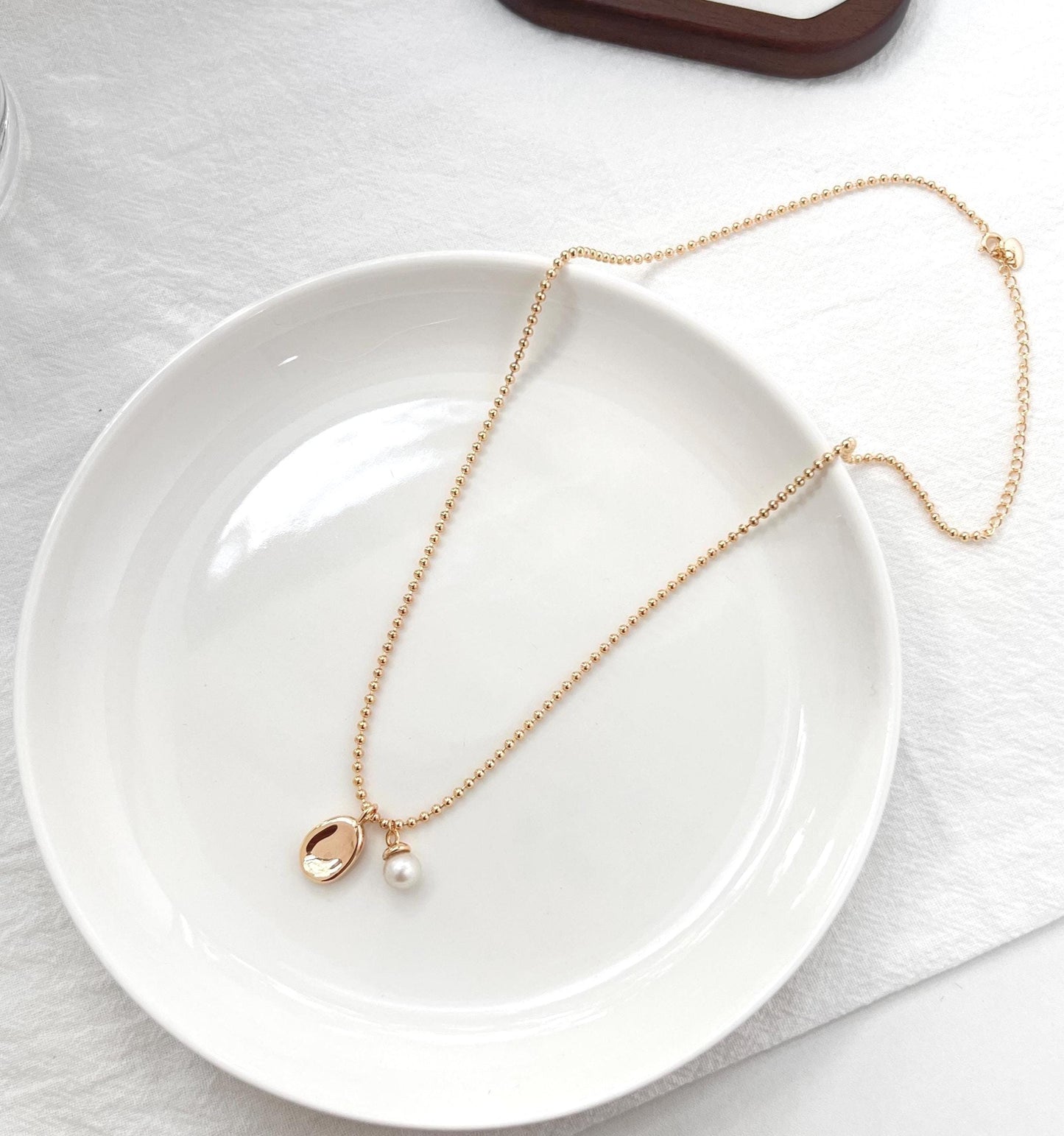Golden Bean Pendant With Petite Freshwater Pearl Charm Necklace