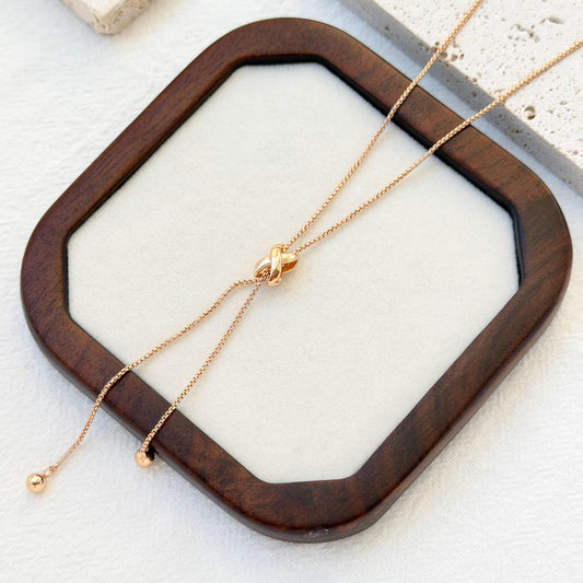 close up of 18k gold knot tassel necklace texture and design