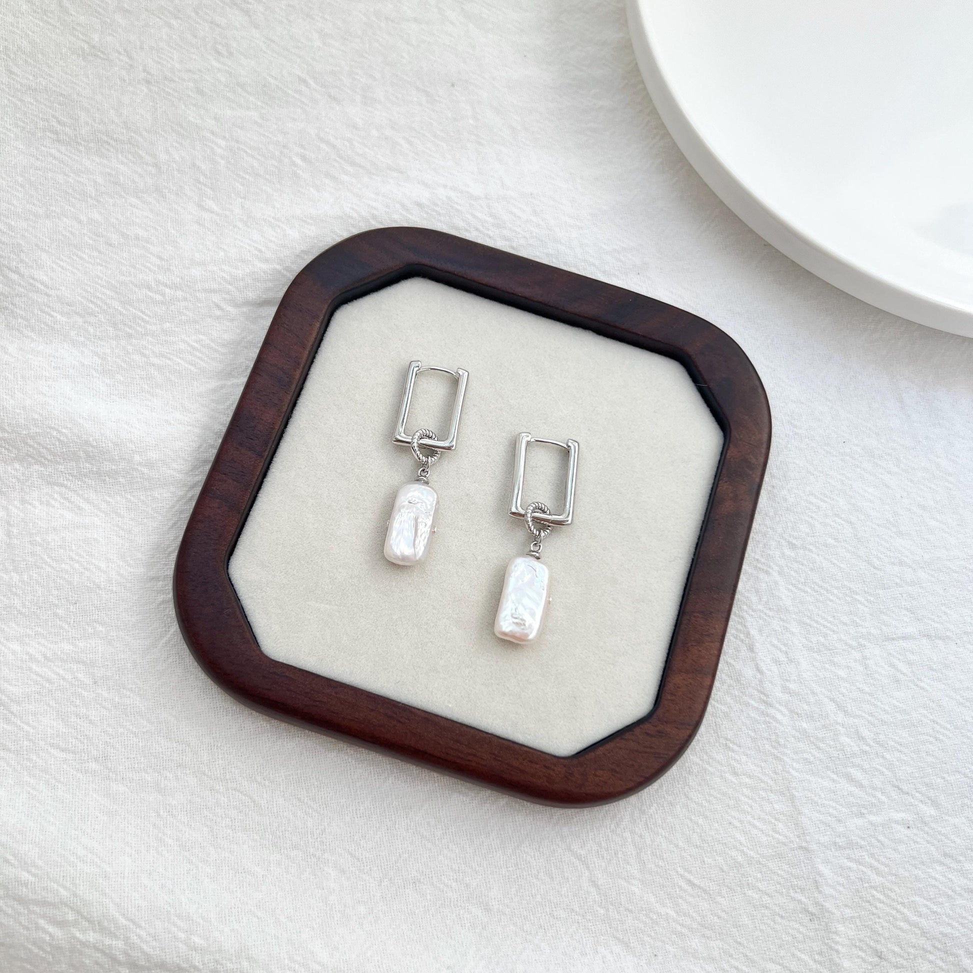 Woman wearing silver rectangle baroque pearl dangle earrings, elegant bridal or everyday accessory