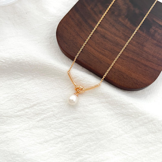 18K gold rope knot pendant with a natural freshwater pearl, minimalist teardrop necklace for bridal and everyday wear.