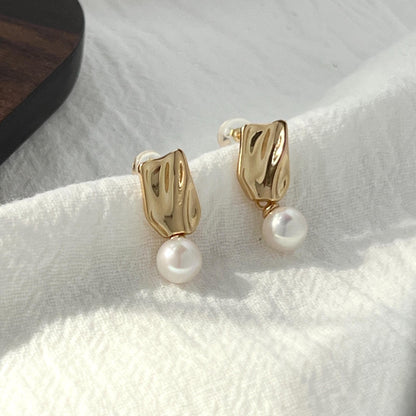 Close-up of baroque freshwater pearl detail on 18K gold earrings