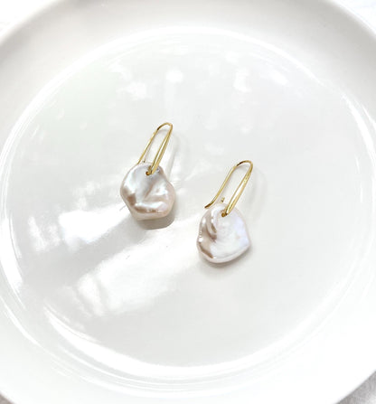 Side view of 18K gold baroque pearl hoop dangle earrings