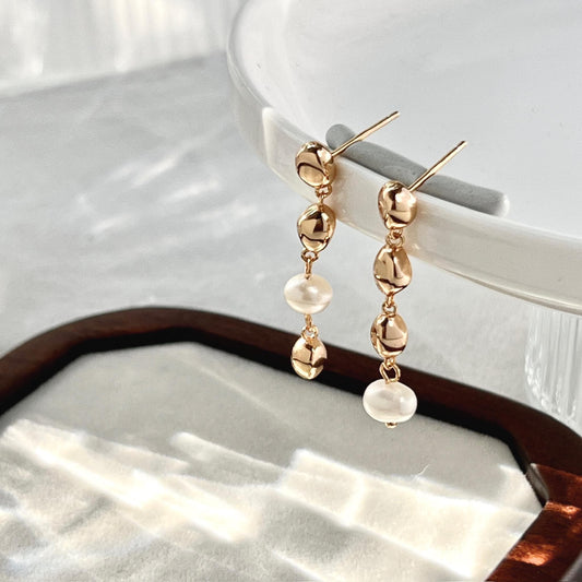 Close-up of baroque freshwater pearls and gold beads on 18K gold earrings