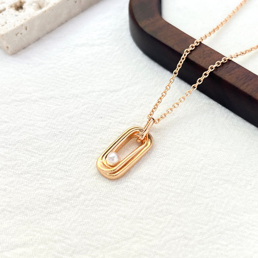 Close-up of delicate freshwater pearl and gold bar on necklace