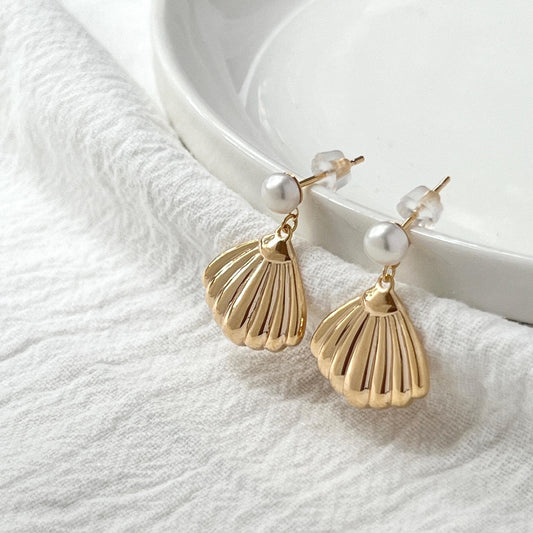 Close-up of vintage shell and freshwater pearl on 18K gold earrings
