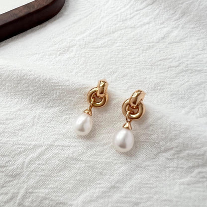Close-up of vintage pearl and Celtic knot detail on 18K gold earrings