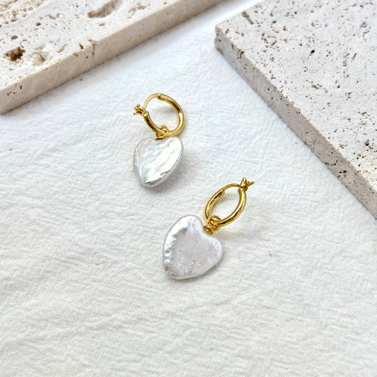 Model wearing minimalist 18K gold heart baroque pearl earrings