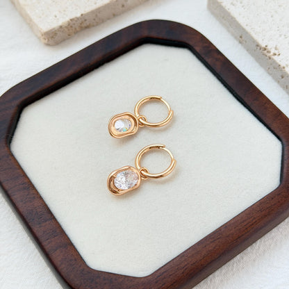 minimalist 18k gold hoop earrings with sparkling oval cut cz stones
