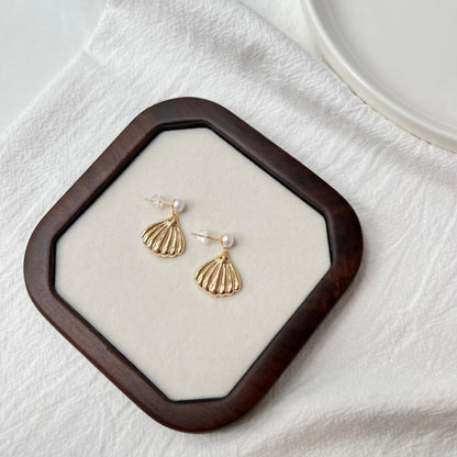 Ocealine Jewelry branding image featuring 18K gold shell drop earrings with pearl studs