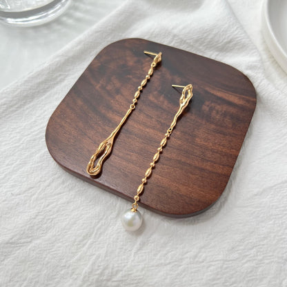 Side view of 18K gold mismatched long drop pearl earrings, minimalist design