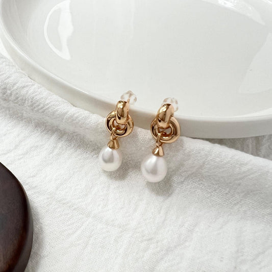 Side view of 18K gold vintage pearl dangling earrings with Celtic knot design