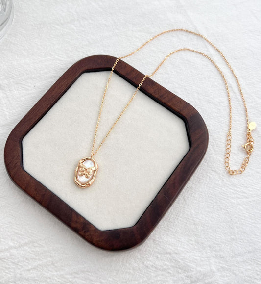 Detail of clasp and extender chain on 18K gold mother-of-pearl butterfly necklace, minimalist delicate jewelry.