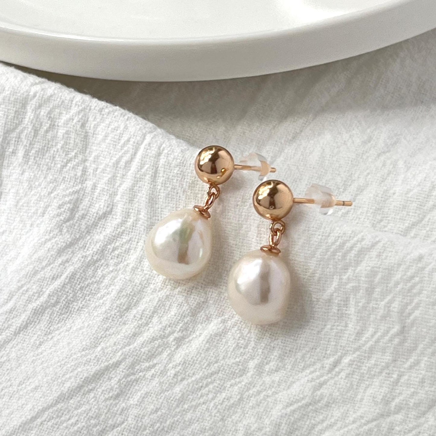 dainty baroque pearl drop earrings in warm vintage gold with soft natural glow