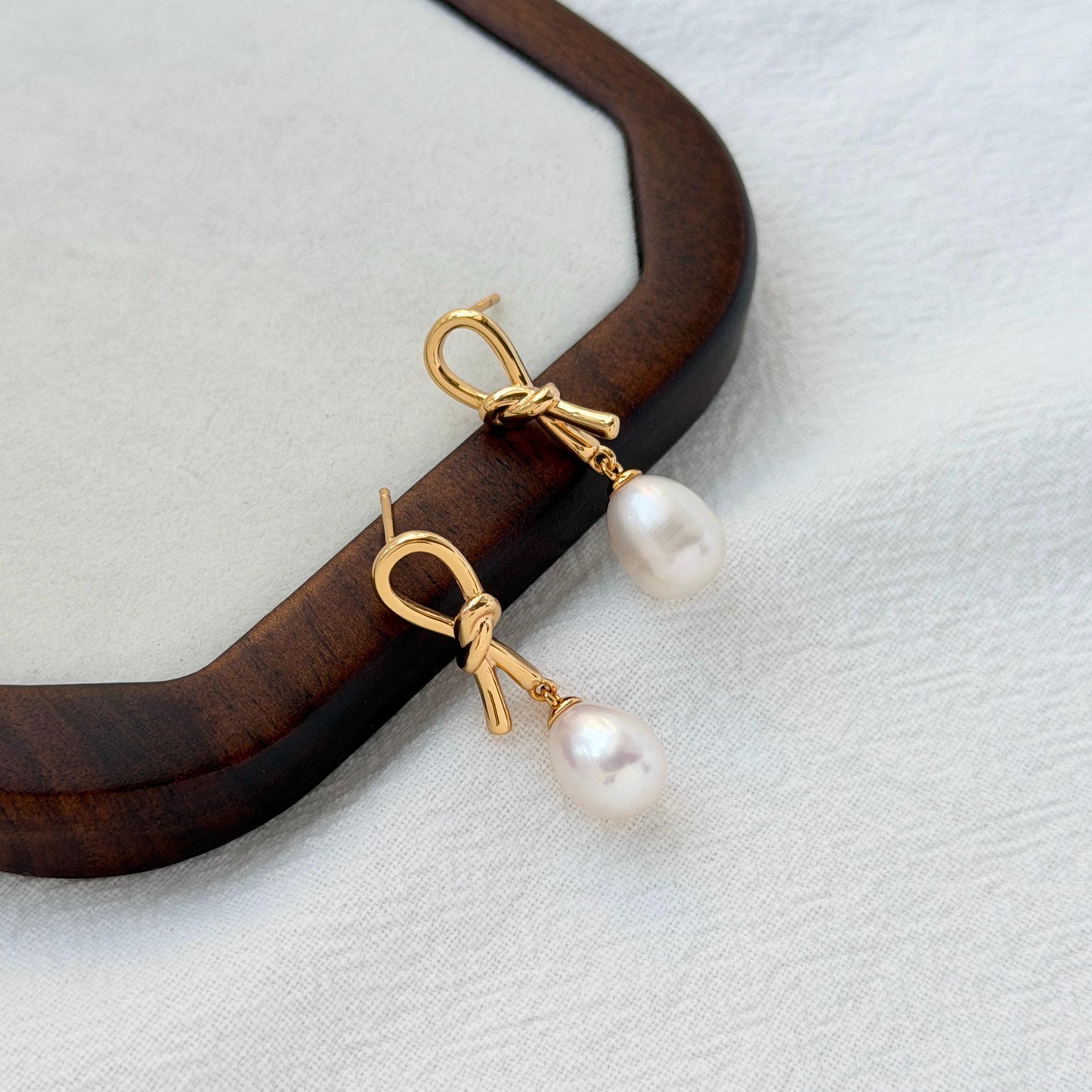 18k gold bow pearl dangle earrings on ear everyday chic accessory
