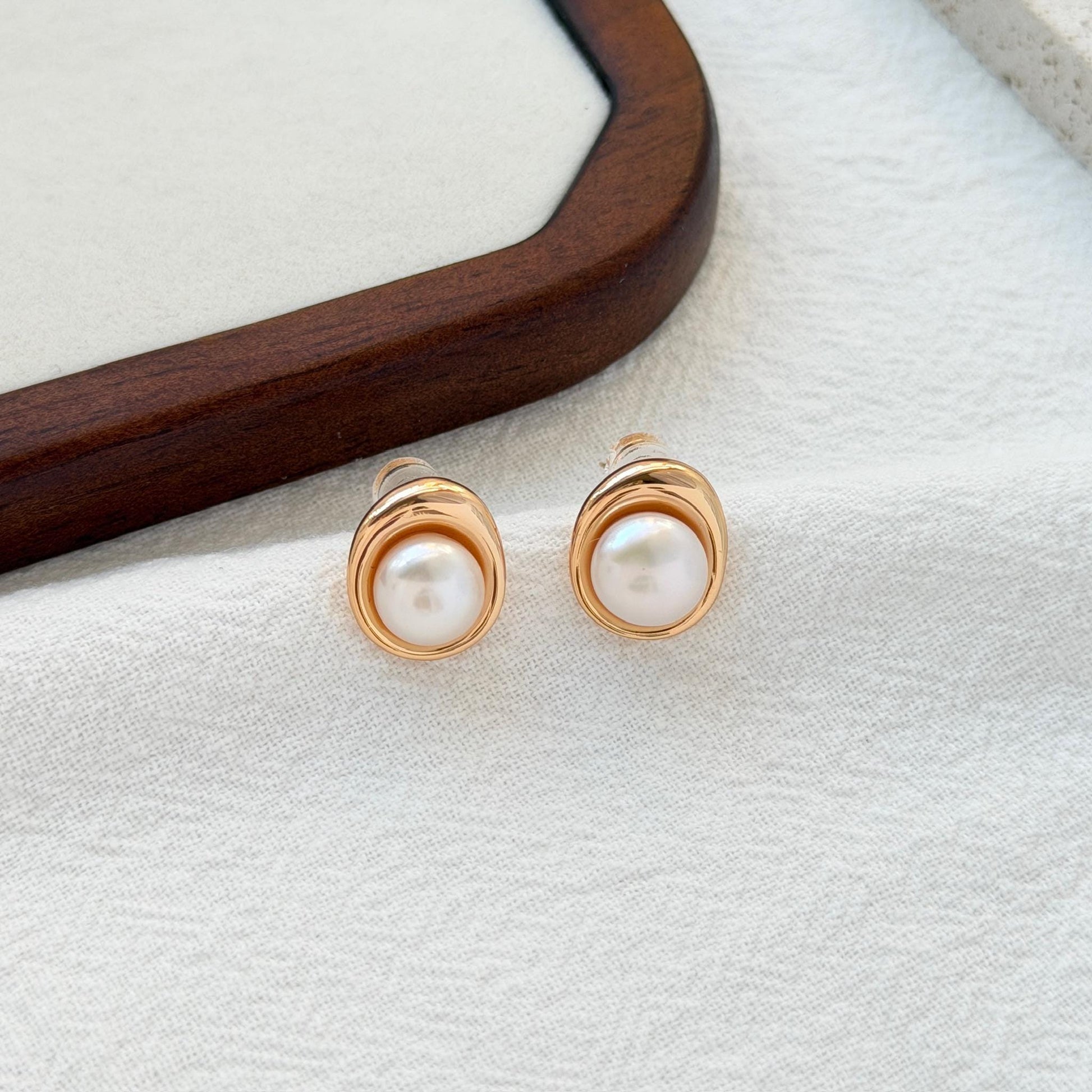 close up of 18k gold vintage freshwater pearl stud earrings texture and shine
