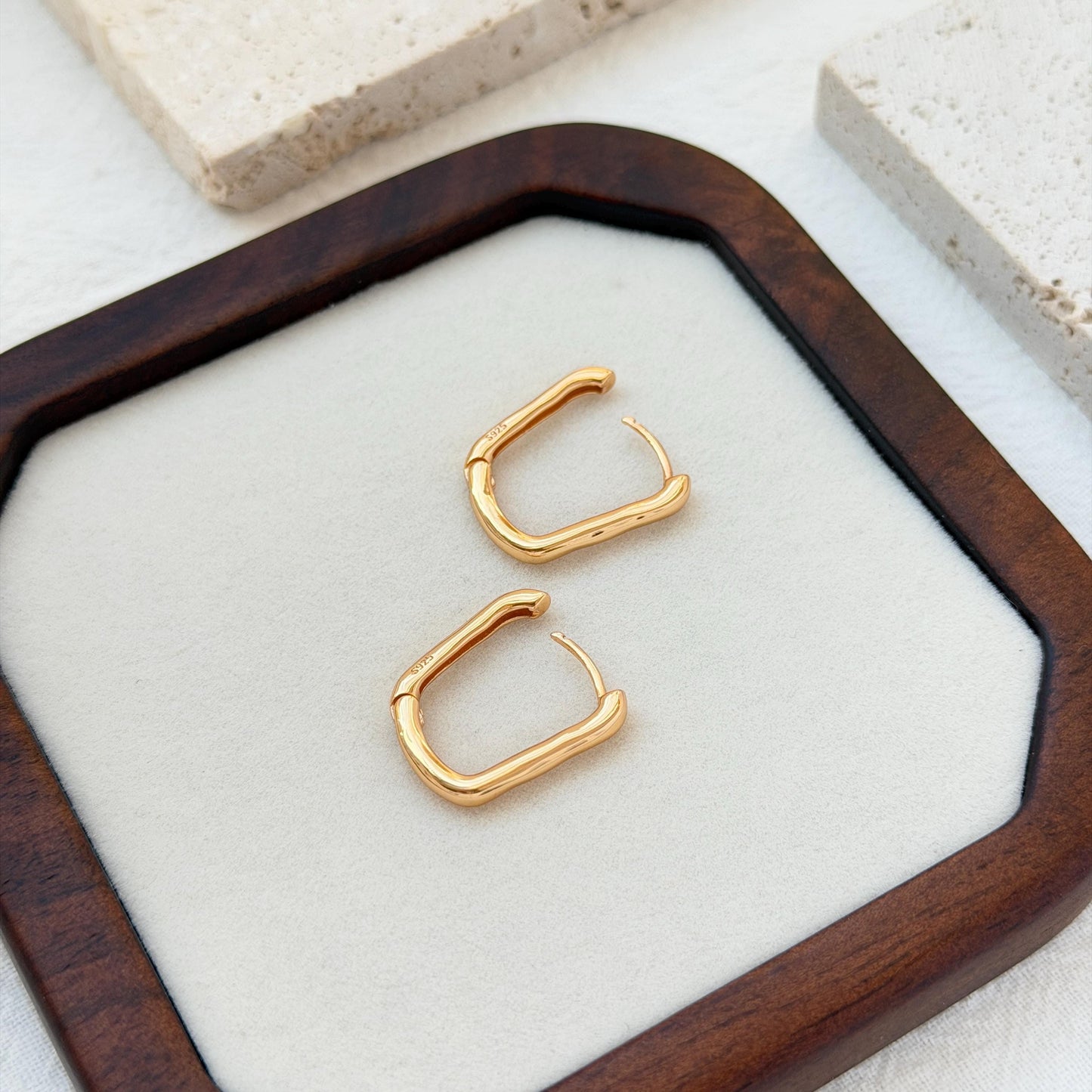 18k gold rectangular huggie hoop earrings on ear sleek everyday jewelry
