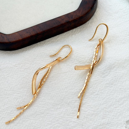close up of 18k gold tassel drop dangle earrings texture and finish
