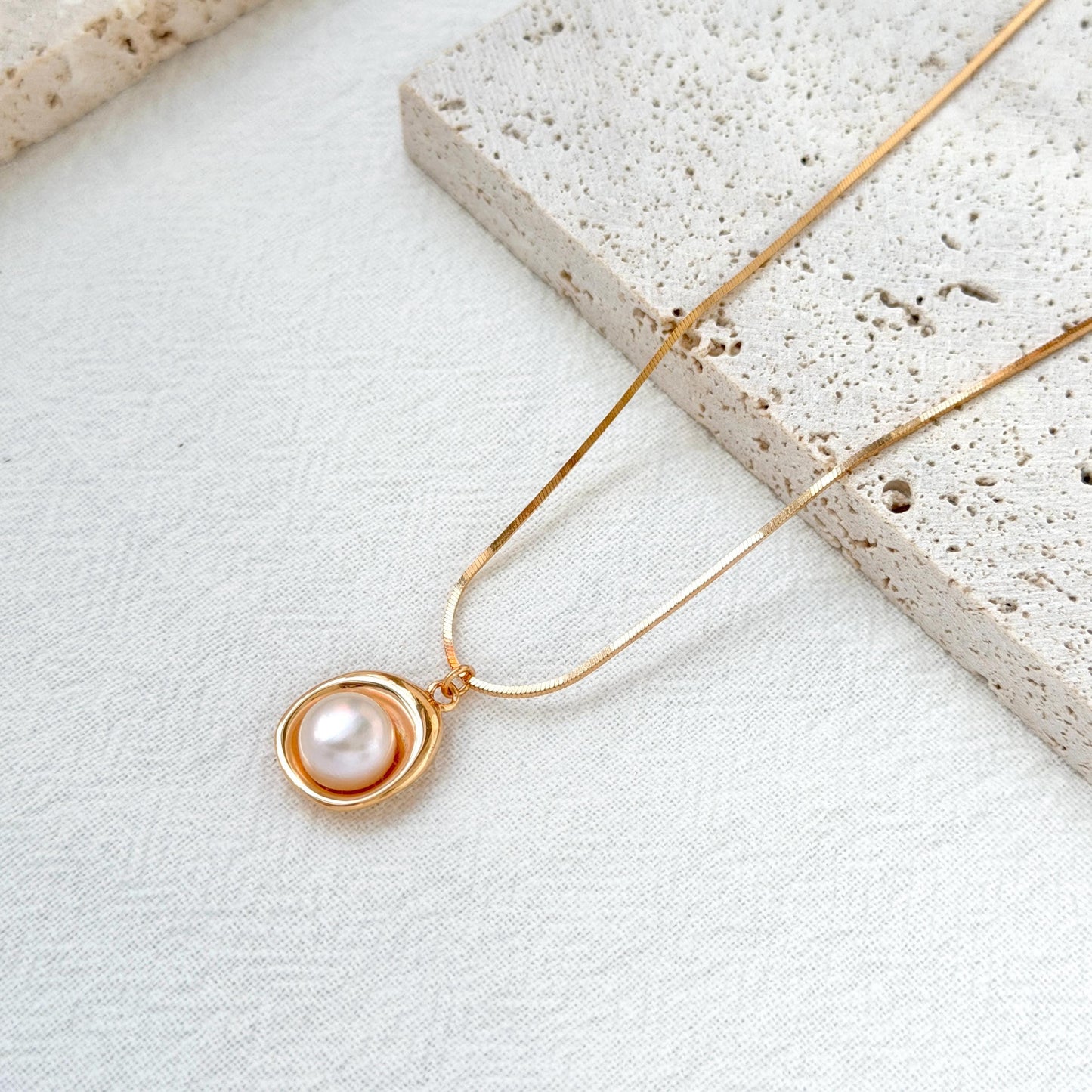 close up of 18k gold freshwater pearl pendant necklace delicate chain and pearl
