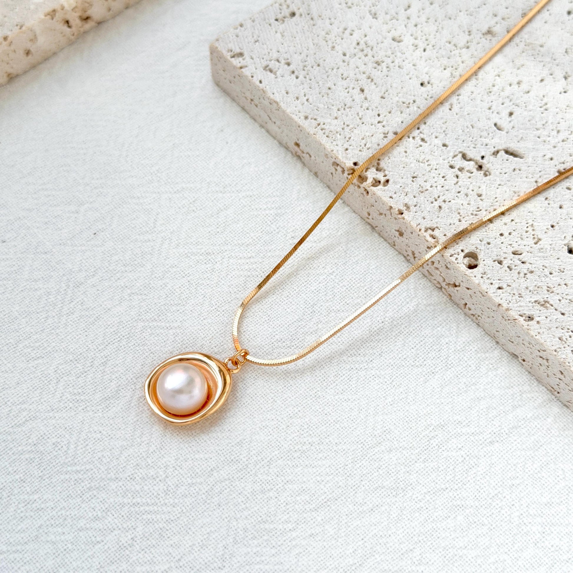 close up of 18k gold freshwater pearl pendant necklace delicate chain and pearl
