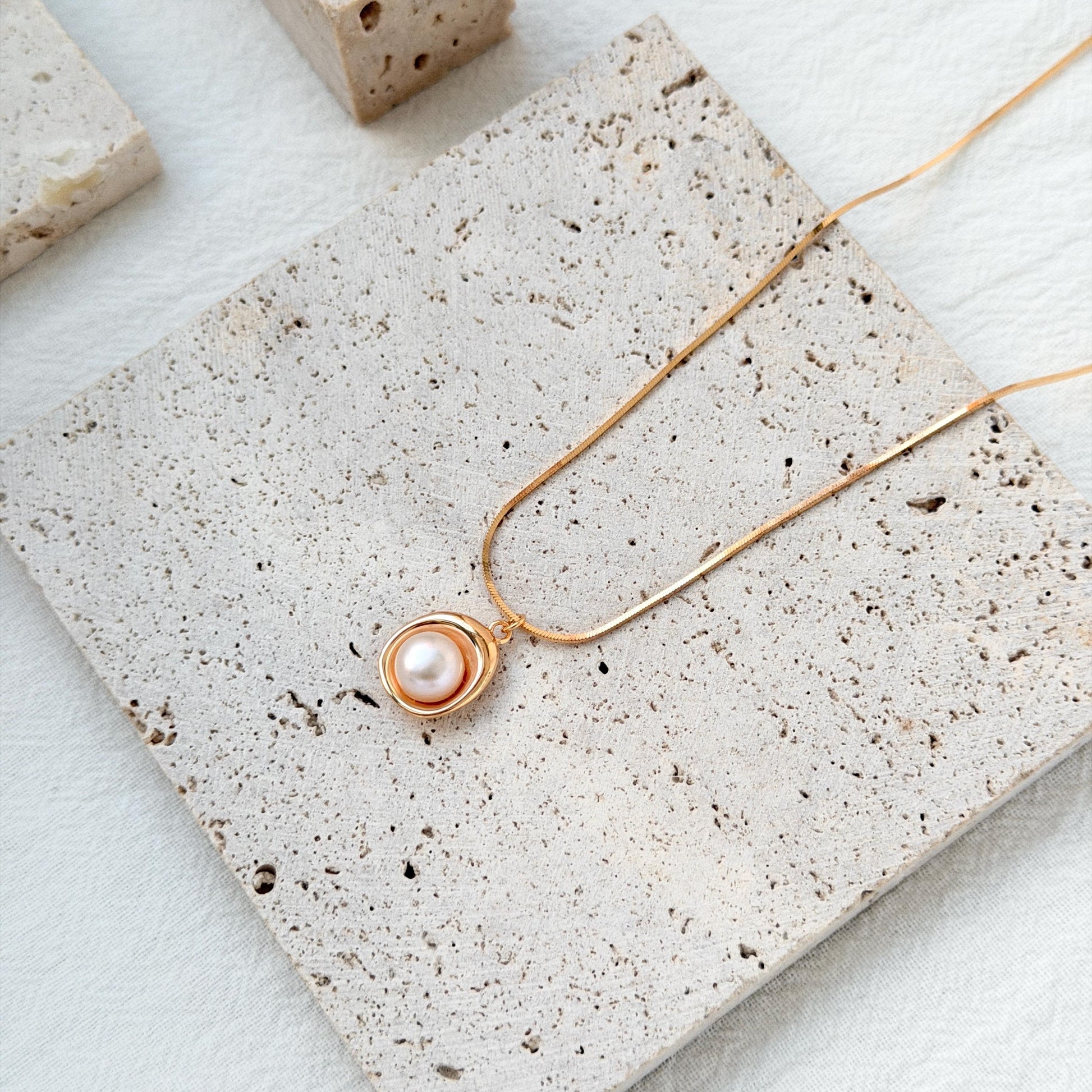 minimalist 18k gold freshwater pearl pendant necklace styled flatlay jewelry
