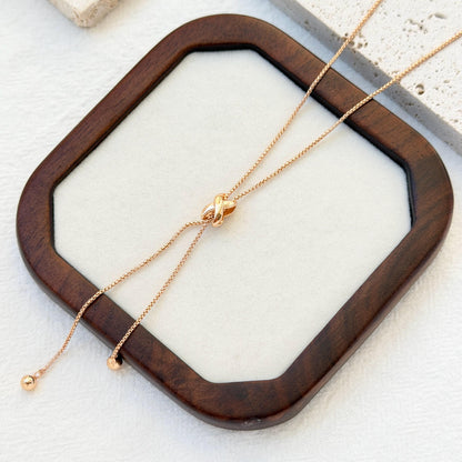 close up of 18k gold knot tassel necklace texture and design
