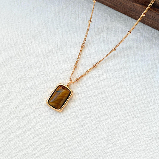 close up of 18k gold vintage tigers eye necklace texture and gemstone pattern
