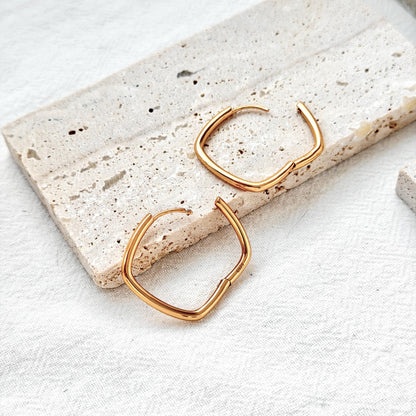 18k gold geometric square huggie hoop earrings on ear modern minimalist style
