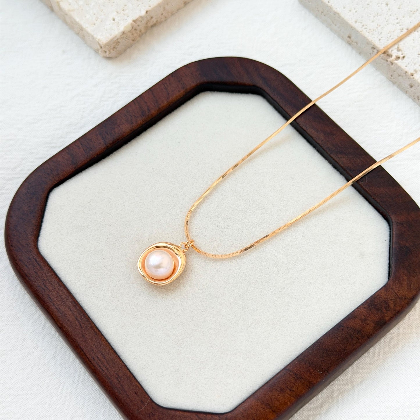 close up of 18k gold freshwater pearl pendant necklace delicate chain and pearl
