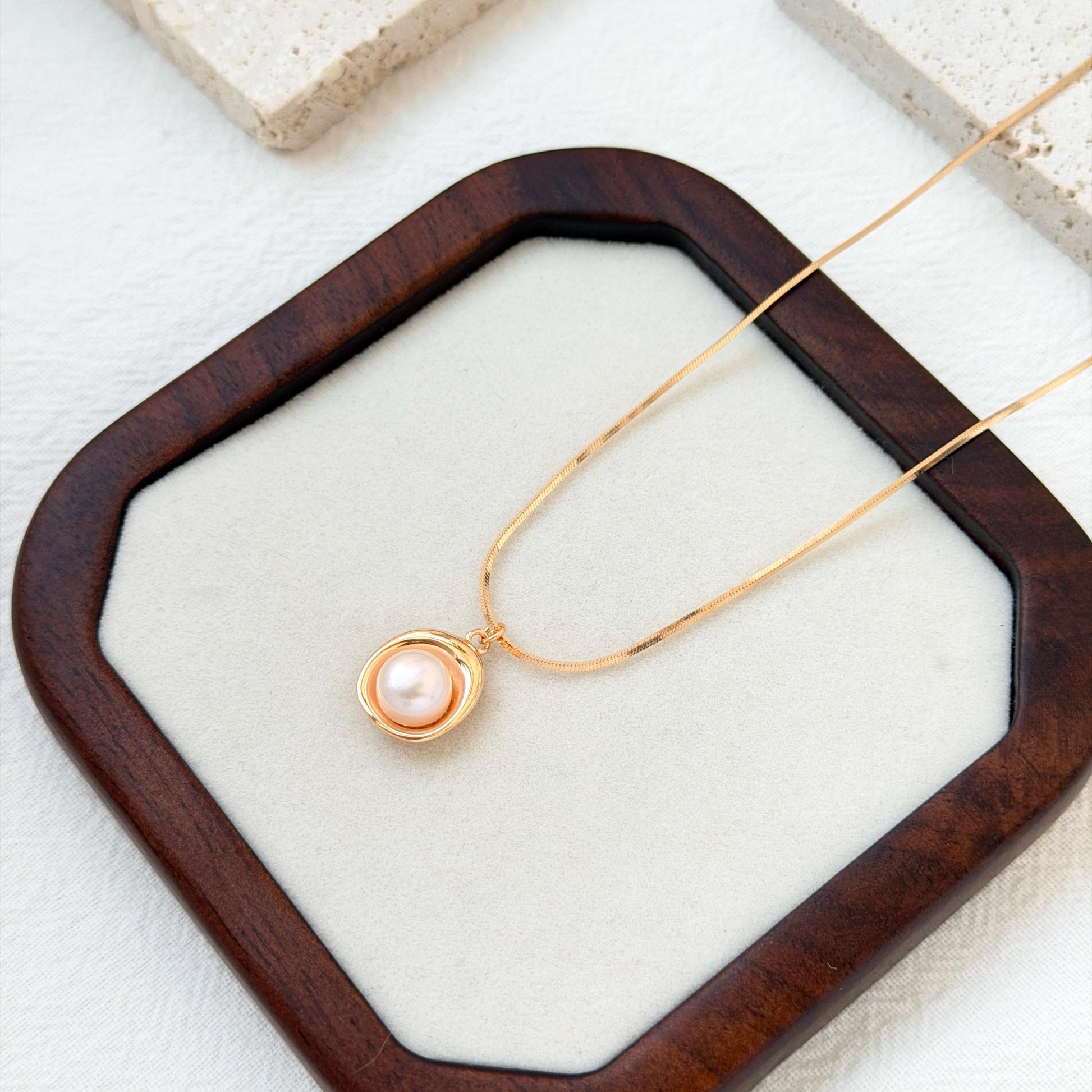 close up of 18k gold freshwater pearl pendant necklace delicate chain and pearl
